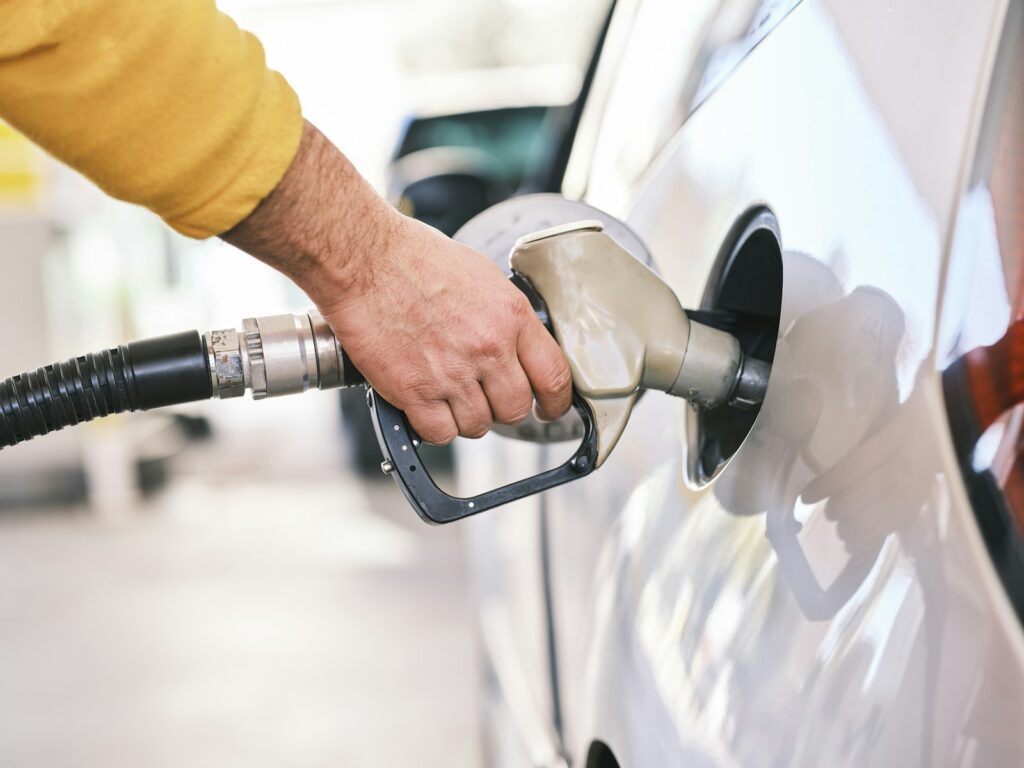 Mann tankt sein Auto an einer Tankstelle – Fahrzeugkosten in der Ausgabenverwaltung erfassen