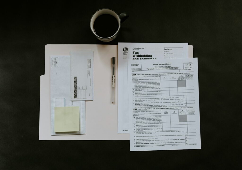 Formulare, Stift und Kaffeetasse auf einem dunklen Schreibtisch für die monatliche Lohnabrechnung
