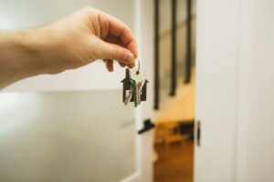 Schlüsseldienst Karlsruhe: Hand hält einen Schlüssel vor einer Wohnungstür