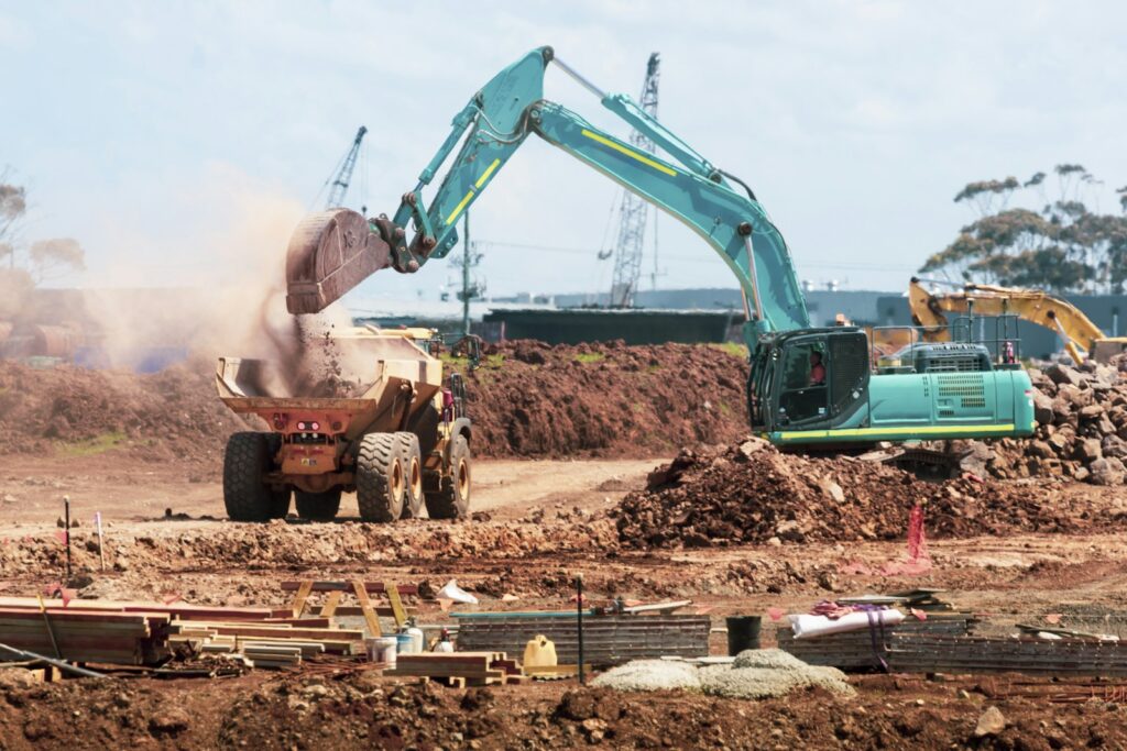 Bagger belädt einen Muldenkipper auf einer Baustelle