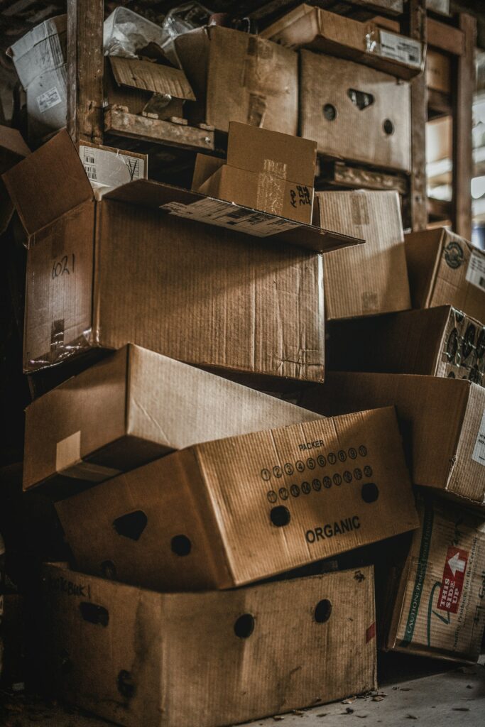 Gestapelte Pappkartons in einem Lagerraum, deren Transport und Verpackung in den Product Footprint einfließen