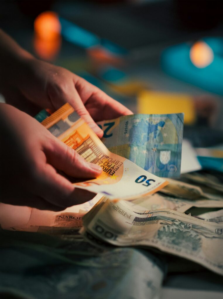 Hände zählen Euro- und Dollar-Banknoten als Symbol für grenzüberschreitende Zahlungen