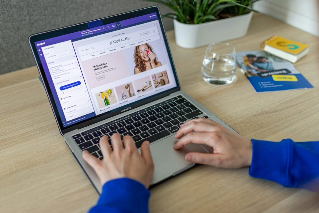 Person arbeitet am Laptop am Online-Shop, den eine Shopify Agentur betreut