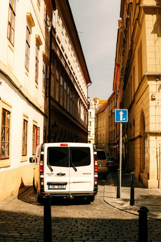Geparkter weißer Transporter in einer engen Straße mit Altbauten