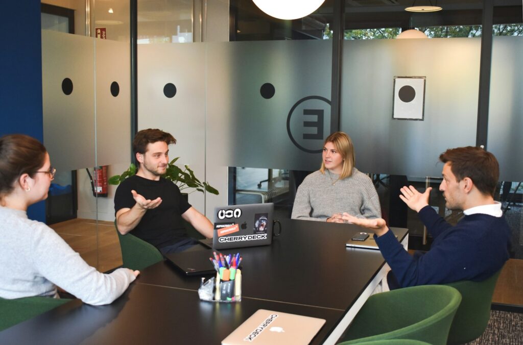 Gründerteam bespricht Rollen und Verantwortlichkeiten an einem Tisch im Büro