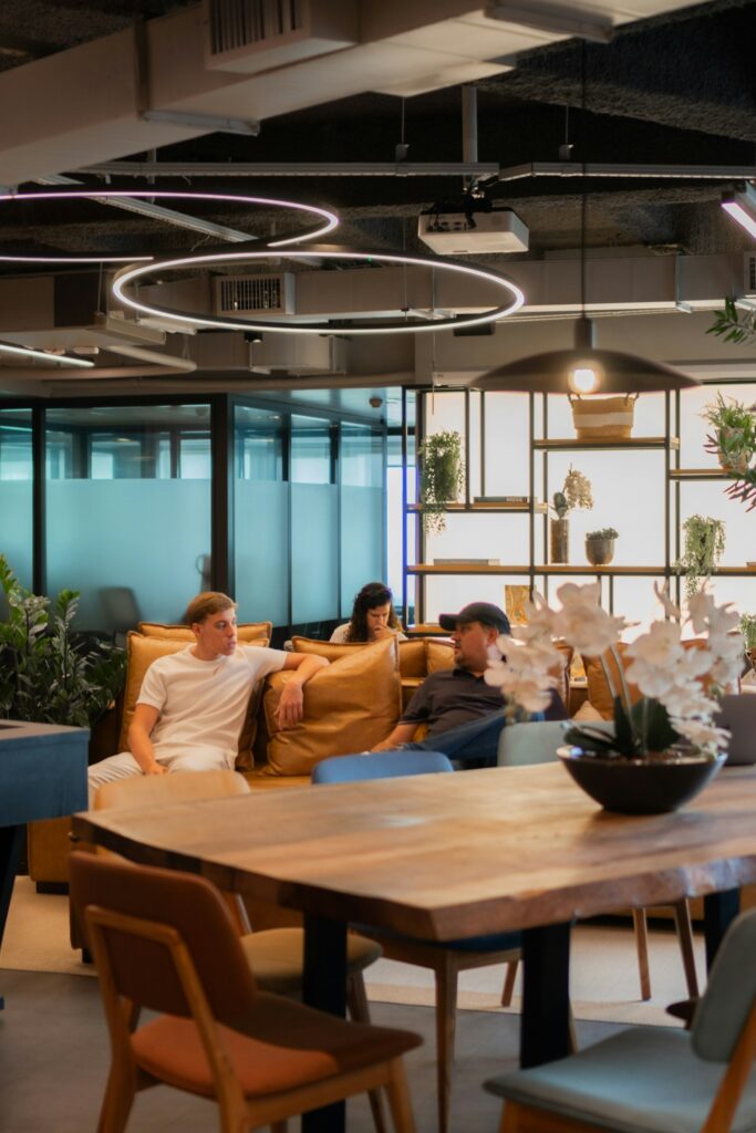 Menschen entspannen sich im Loungebereich eines modernen Büros, in dem ein Massagesessel Platz finden kann