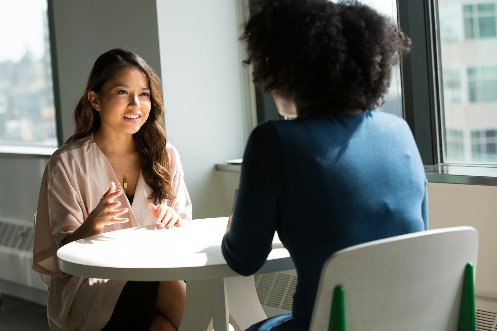 Zwei Frauen sitzen sich bei einem AVGS Coaching im Gespräch gegenüber