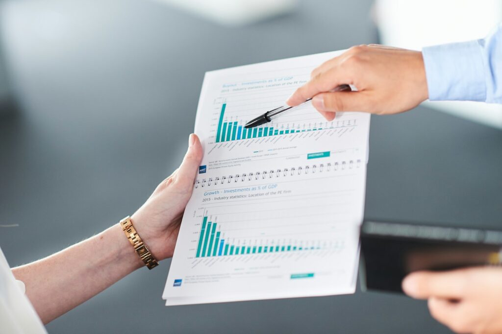 Zwei Personen analysieren ein Dokument mit Balkendiagrammen, bevor sie in Startups investieren