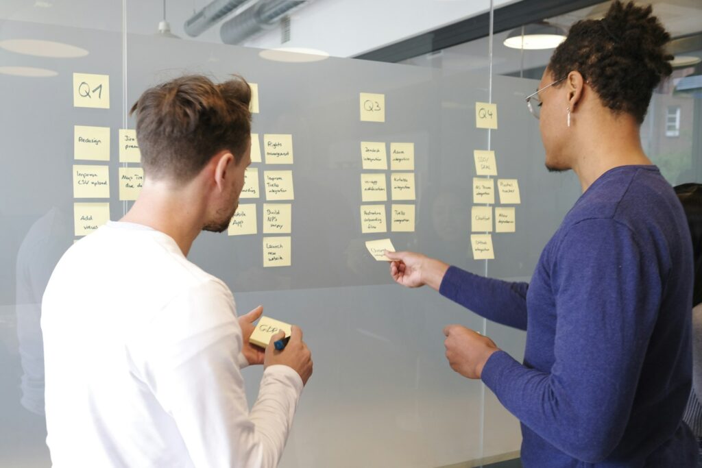 Zwei Personen planen ein SaaS-Projekt mit Haftnotizen an der Wand