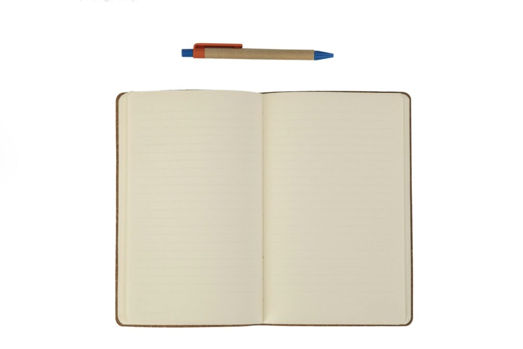 Offenes Notizbuch mit linierten Seiten und Kugelschreiber als klassischer Werbeartikel