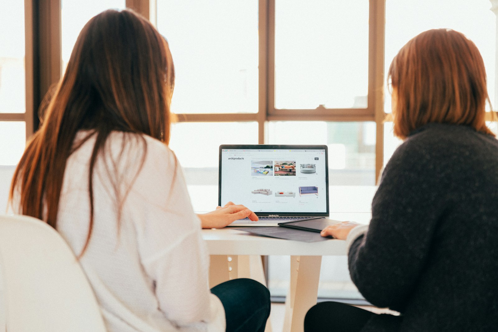 Zwei Frauen sprechen im Bewerbungsgespräch über Inhalte auf einem Laptop – IT Recruiting im Startup