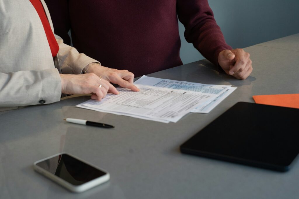 Zwei Personen gehen am Tisch gemeinsam Vertragsdokumente durch