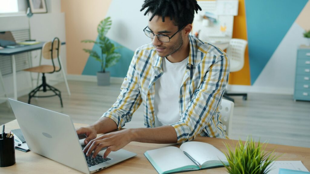 Mann schreibt am Laptop einen Fachbeitrag für ein Branchenportal