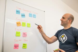 Gründer plant am Whiteboard mit Haftnotizen den nächsten Sprint, agile Zertifizierung in der Praxis