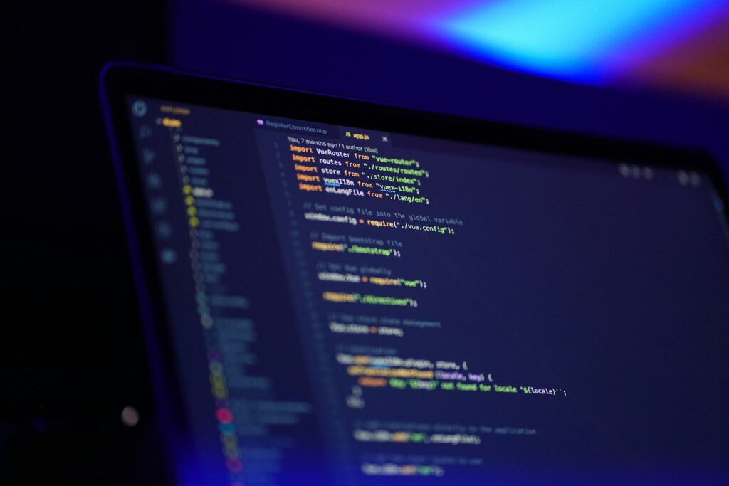 Laptop-Bildschirm mit farbigem Programmcode, Symbol für KI-Tools in der Softwareentwicklung