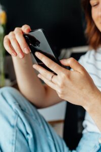 Person hält ein Smartphone, auf dem ein Chatbot Kundenfragen beantwortet