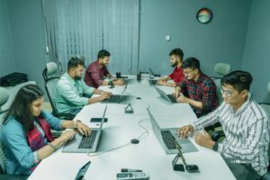 Gruppe junger Fachkräfte arbeitet mit Laptops an einem Tisch als Symbolbild für Fachberufe 2026