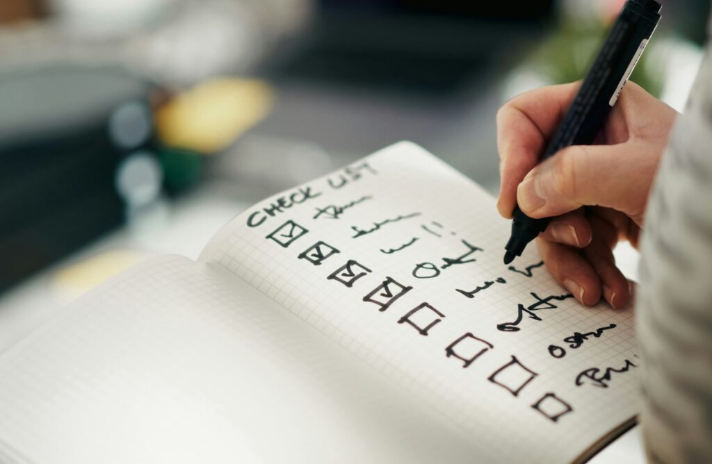 Person hakt Punkte auf einer Checkliste ab, bevor die Startup-Website live geht