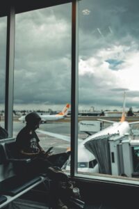 Mann nutzt am Flughafen sein Smartphone mit einer Reise-eSIM für mobiles Internet