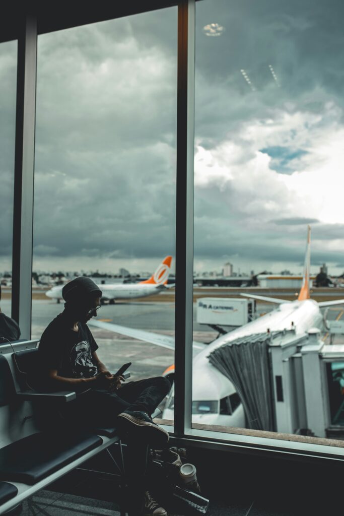 Mann nutzt am Flughafen sein Smartphone mit einer Reise-eSIM für mobiles Internet