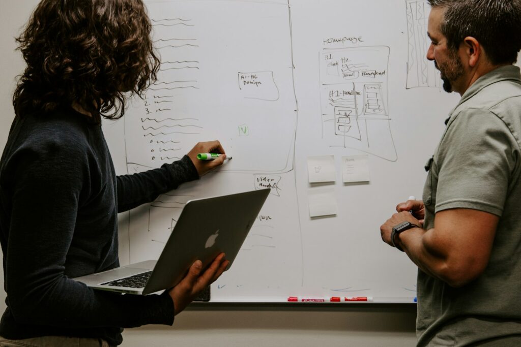Mann plant an einem Whiteboard die Vertriebsphasen für ein CRM