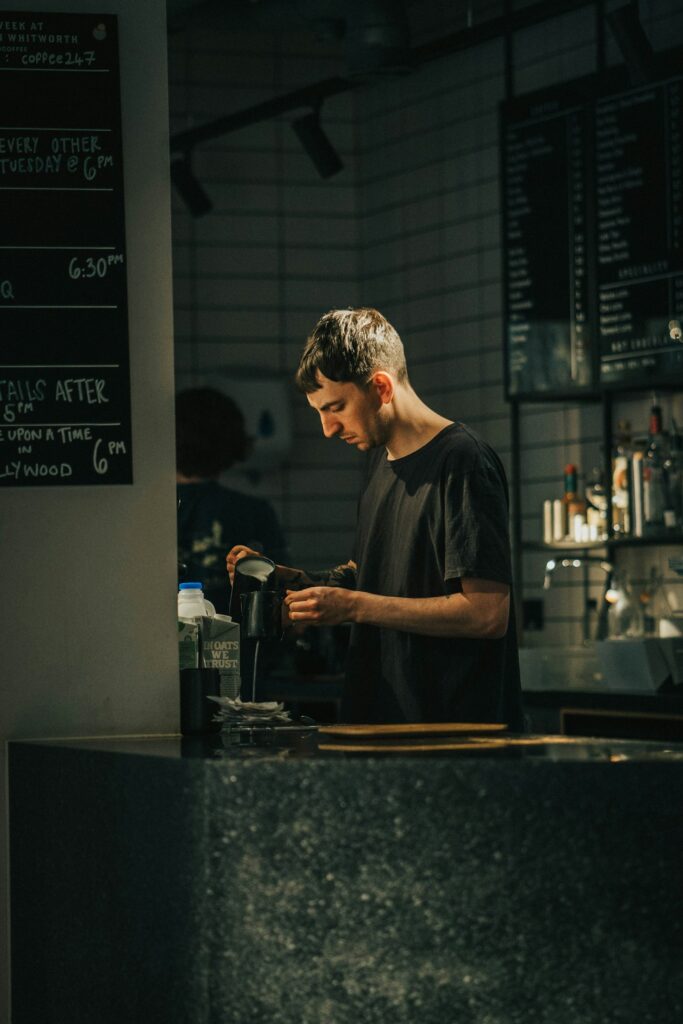 Mitarbeiter steht an der Theke eines Restaurants und bedient Gäste