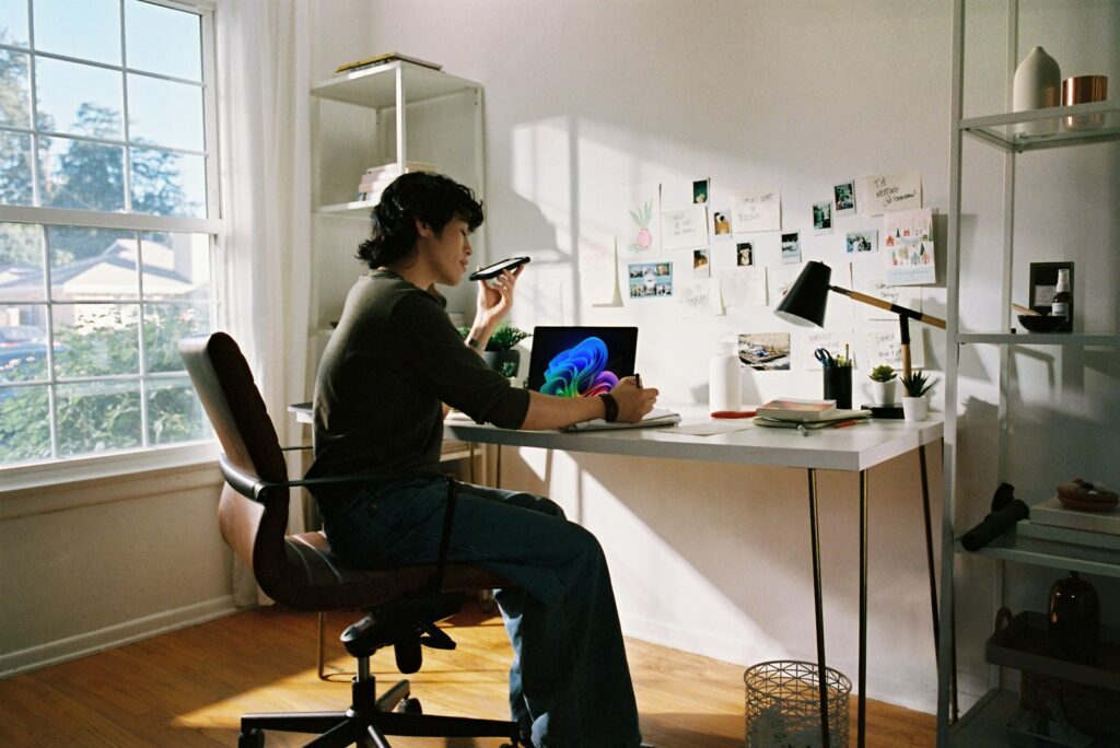 Selbstständige Person am Schreibtisch mit Laptop und Telefon beim Vergleich von Tarifen