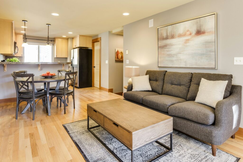 Möbliertes Apartment mit Sofa, Esstisch und offener Küche als Beispiel für temporäres Wohnen bei Projekteinsätzen