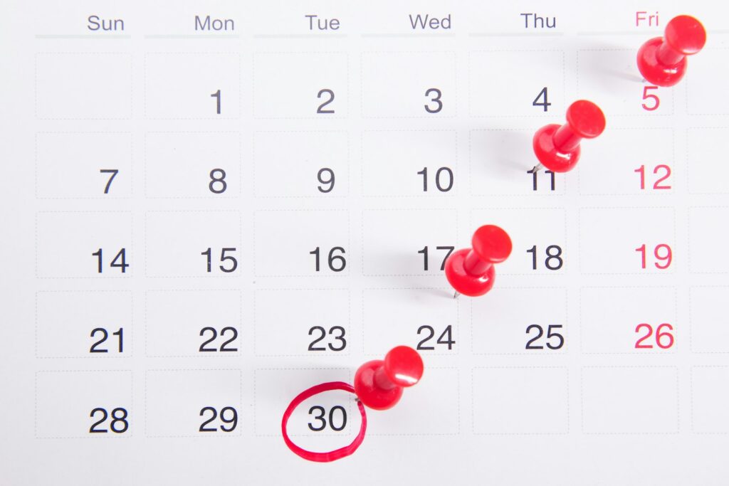 Wandkalender mit roten Pinnnadeln zur Urlaubsplanung von Minijobbern