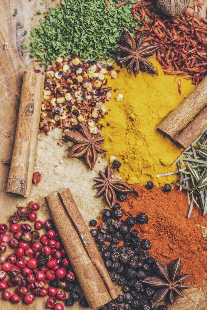 Zimtstangen, Sternanis, Pfefferkörner und gemahlene Gewürze auf einem Tisch