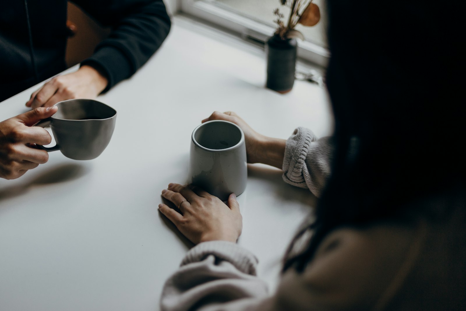 Zwei Personen im Gespräch am Tisch mit Kaffeetassen, Alltag der lateralen Führung